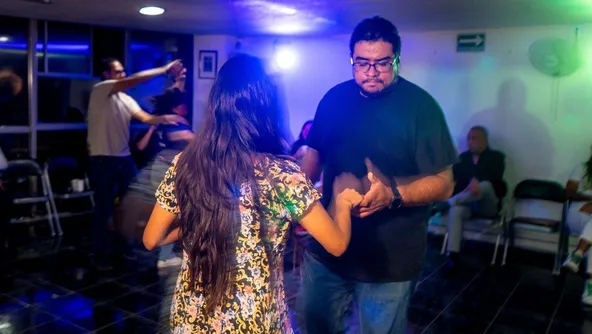 Alumno bailando con instructor en un evento en Academia de baile ARIA