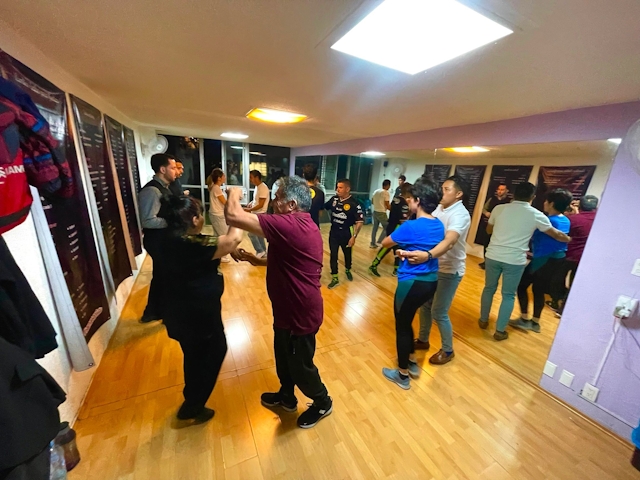 Estudiantes bailando con instructores y amigos